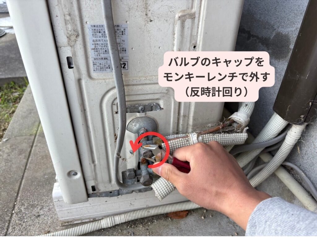 バルブキャップをモンキーレンチで外す様子