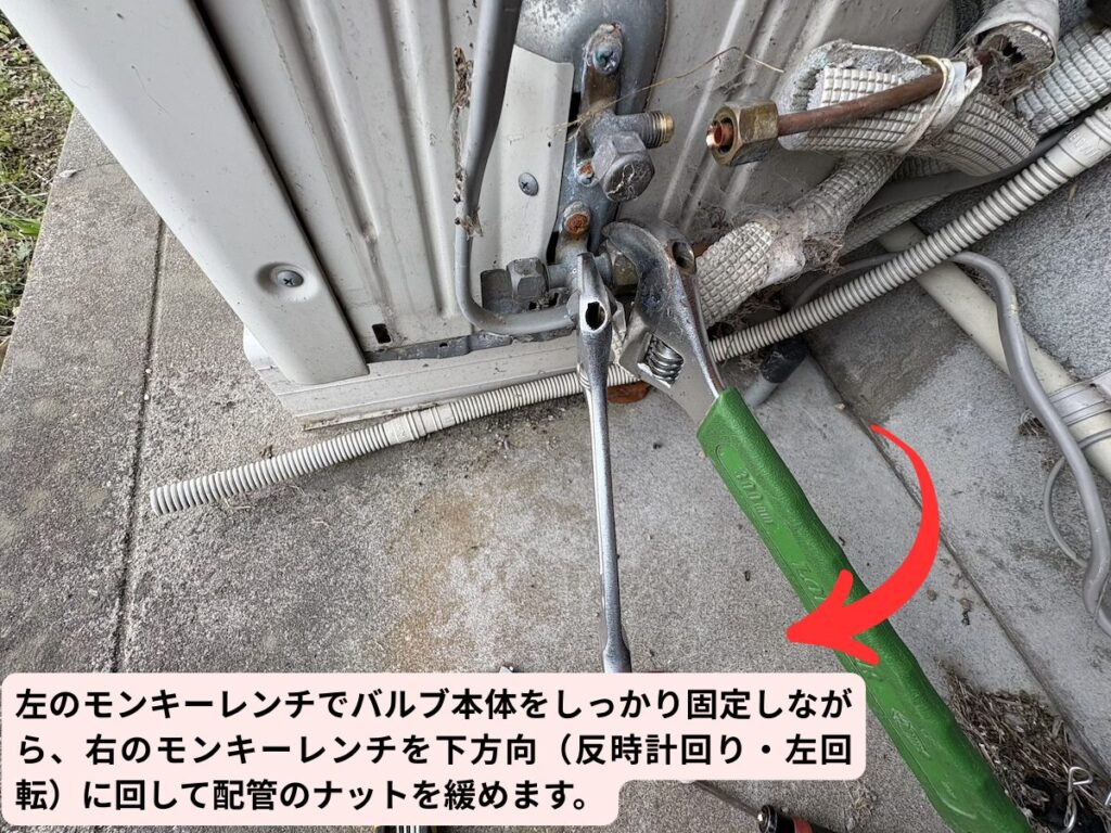 モンキーレンチで銅管パイプのナットを外す様子