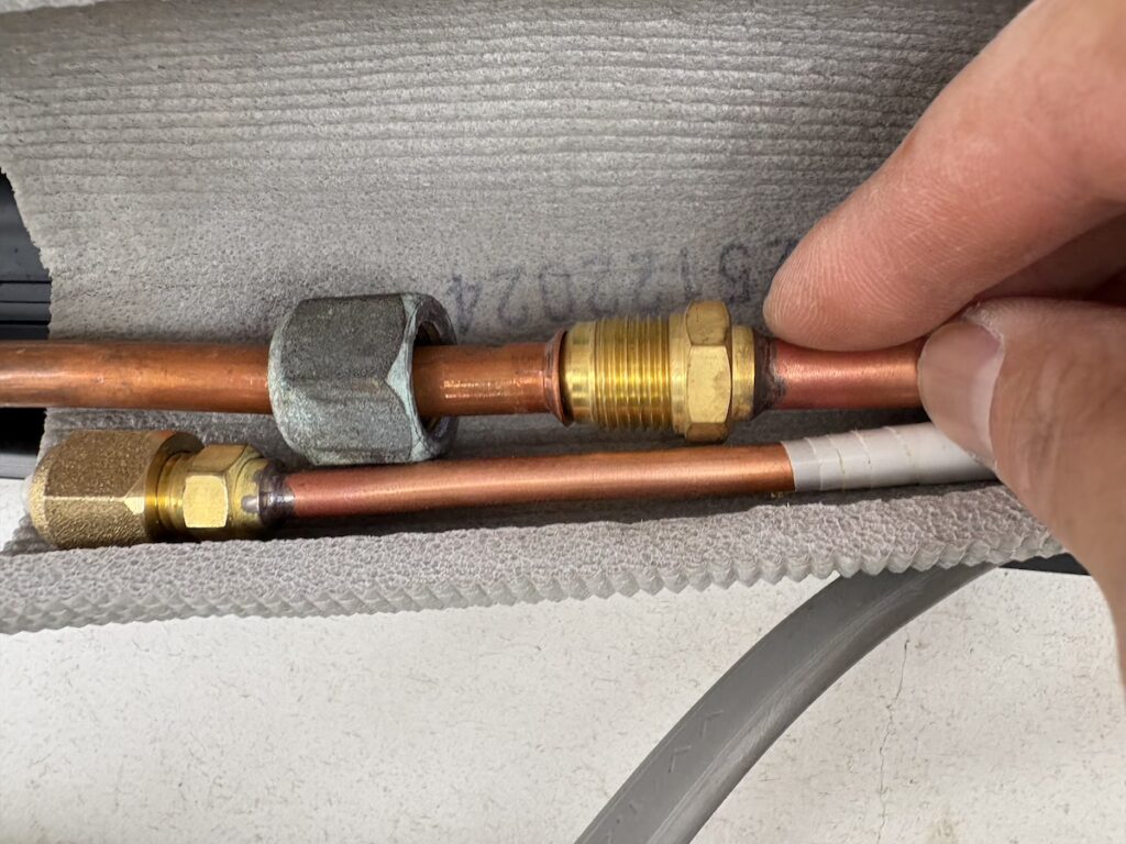 配管を手締めで接続する様子